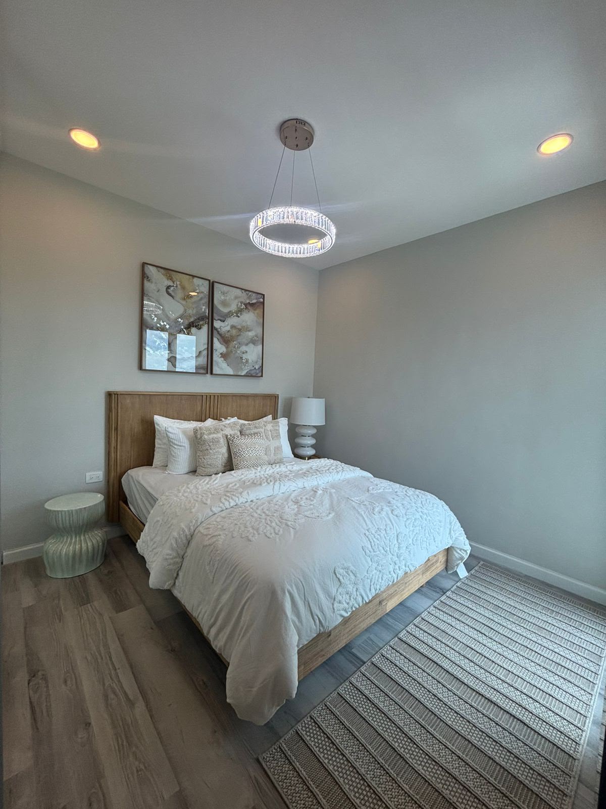 Bedroom with chandelier and abstract art